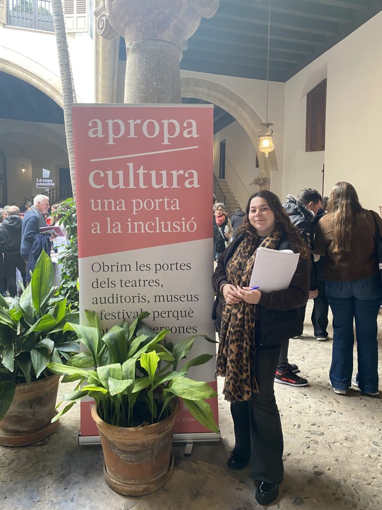 Chica posando con cartel de Apropa Cultura