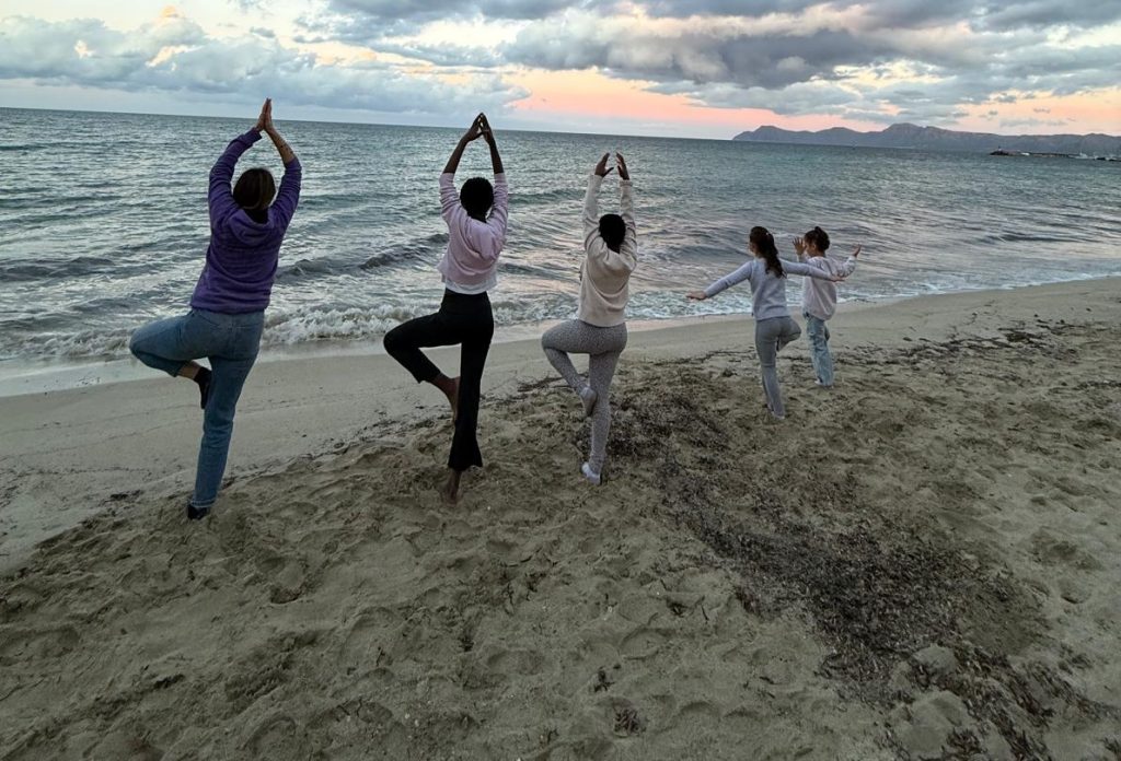Chicos haciendo yoga en la playa
