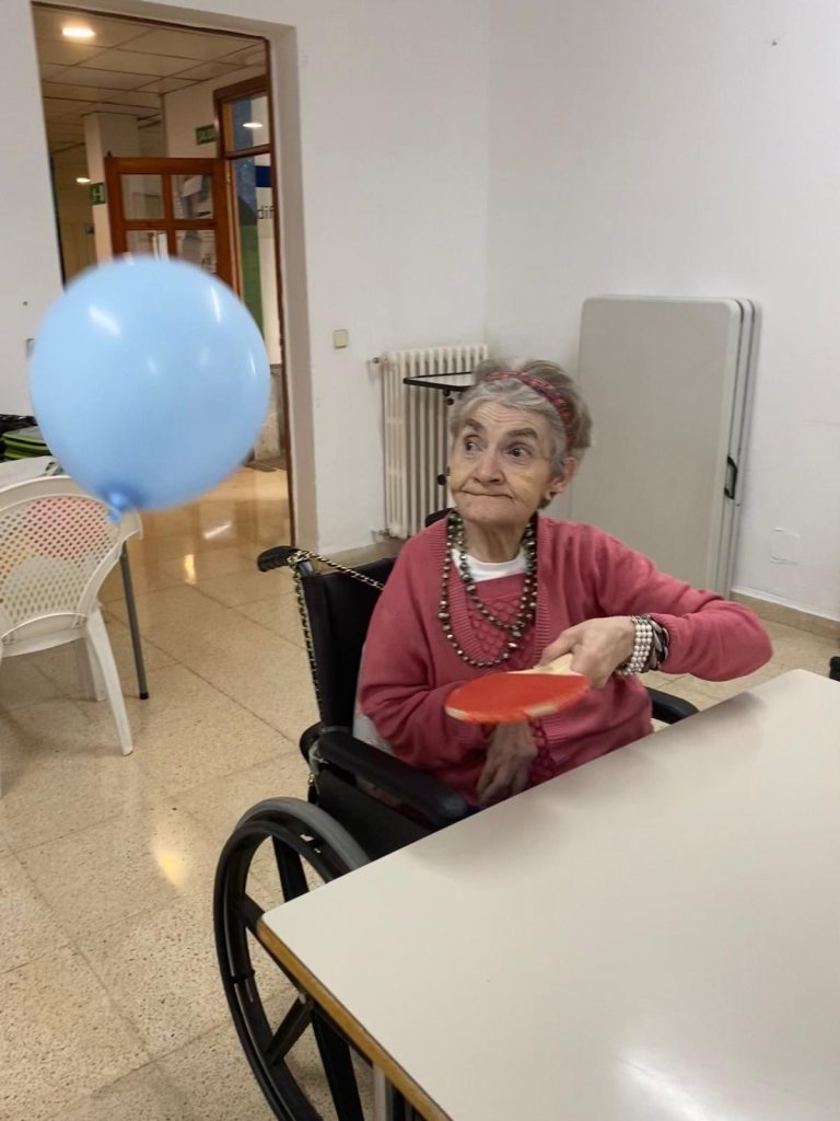 Personas mayores jugando al tenis de mesa con globos