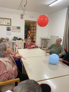 Personas mayores jugando al tenis de mesa con globos