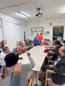 Personas mayores jugando al tenis de mesa con globos