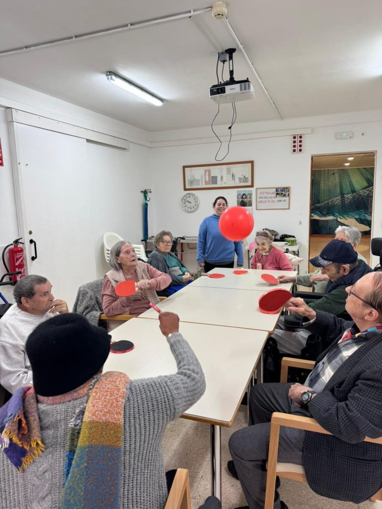 Personas mayores jugando al tenis de mesa con globos