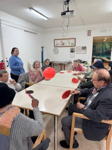 Personas mayores jugando al tenis de mesa con globos
