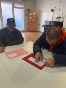Personas escribiendo y haciendo un mural
