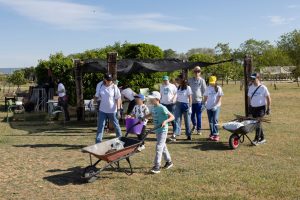 Niños y adultos llevando carretillas
