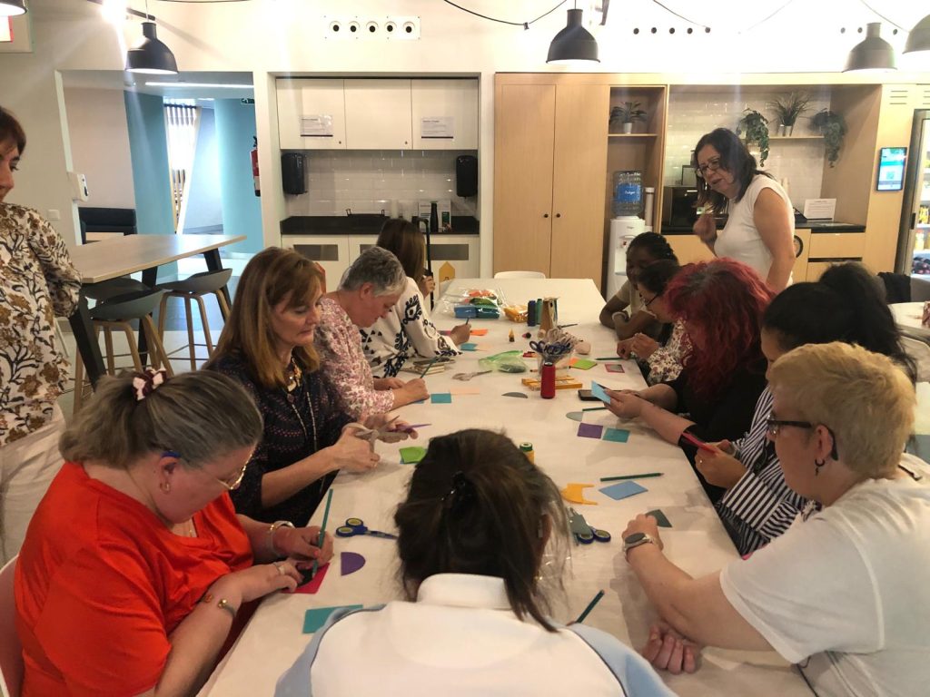 Personas con discapacidad haciendo un taller de manualidades con voluntarios de una empresa