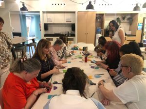 Personas con discapacidad haciendo un taller de manualidades con voluntarios de una empresa