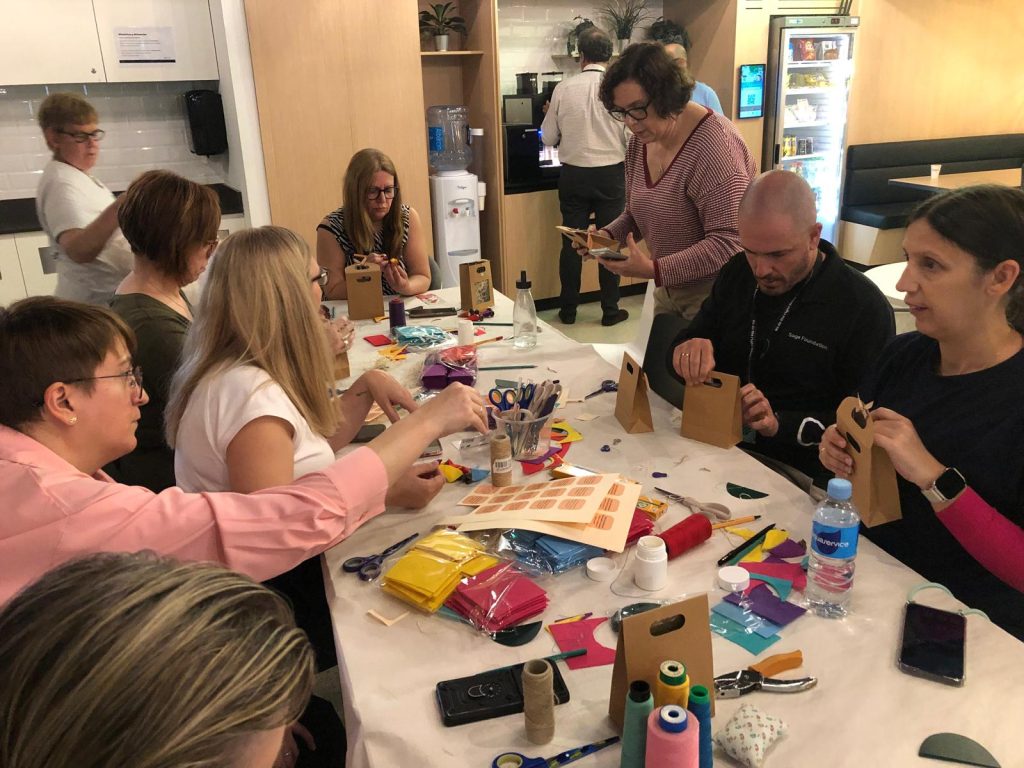Personas con discapacidad haciendo un taller de manualidades con voluntarios de una empresa