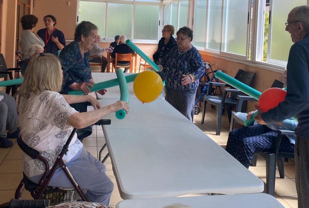 Personas mayores jugando a tenis adaptado en residencia