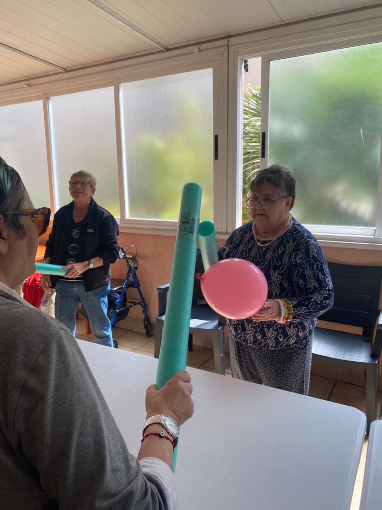Personas mayores jugando a tenis adaptado en residencia