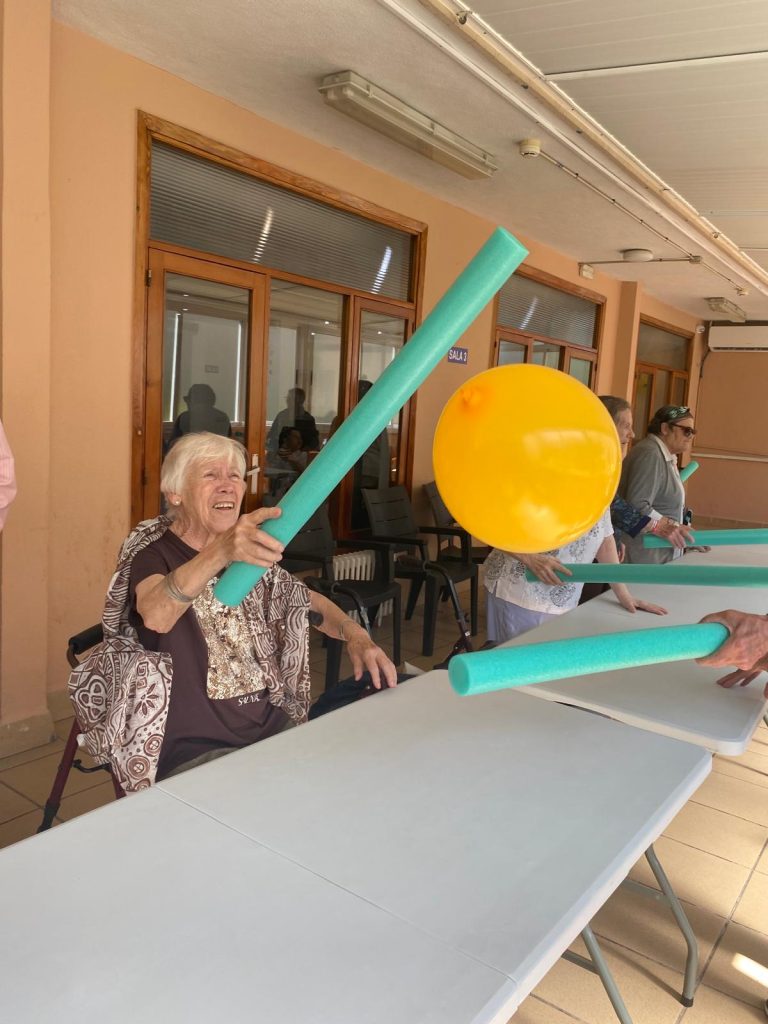 Personas mayores jugando a tenis adaptado en residencia