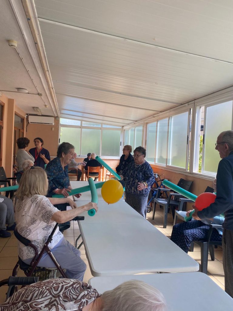 Personas mayores jugando a tenis adaptado en residencia
