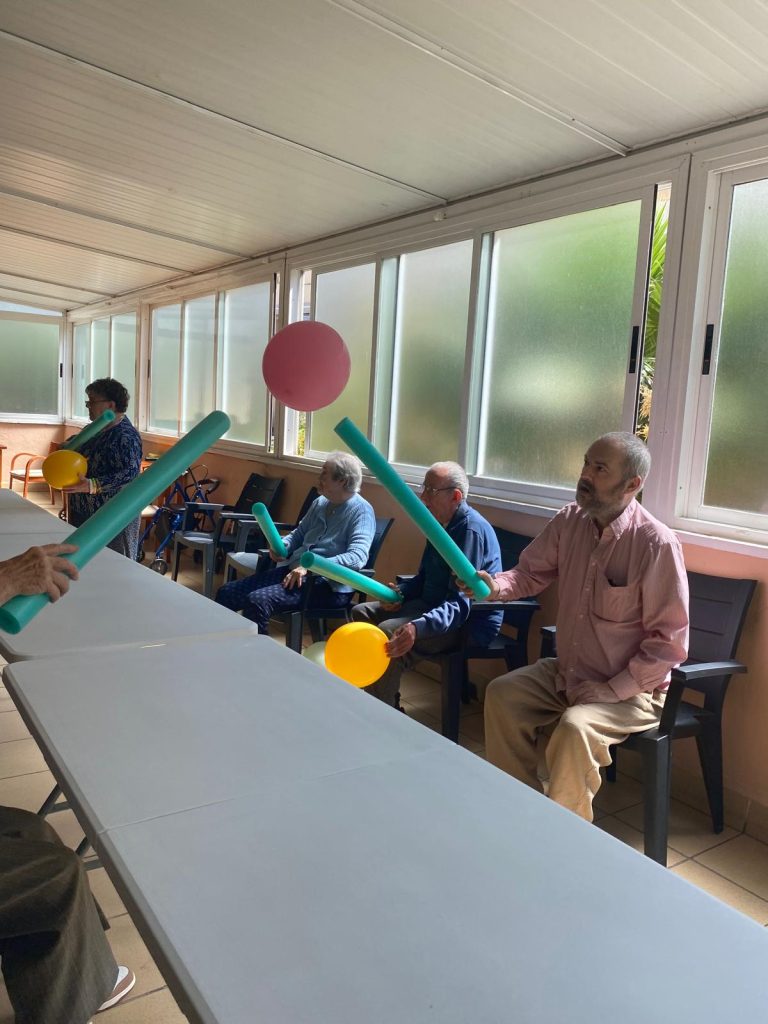 Personas mayores jugando a tenis adaptado en residencia