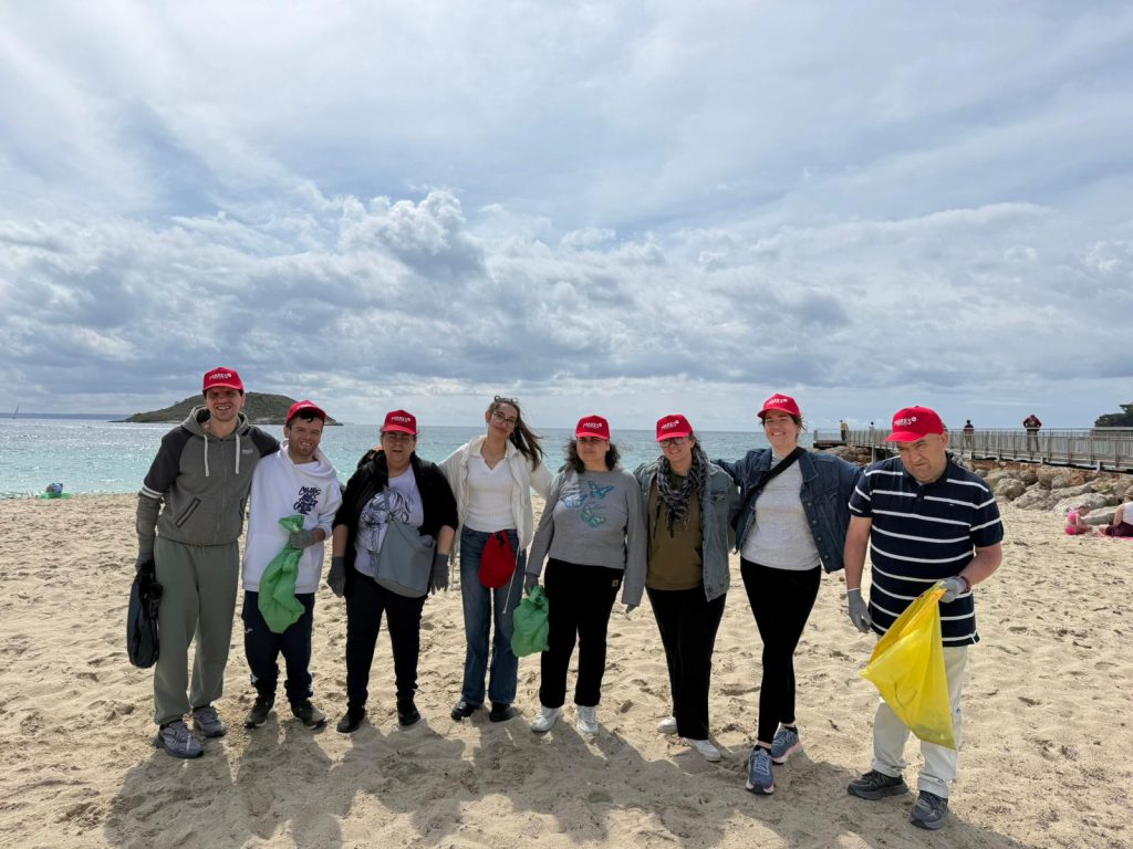 Chicos en la playa recogiendo basura
