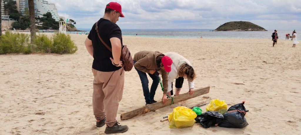 Chicos en la playa recogiendo basura