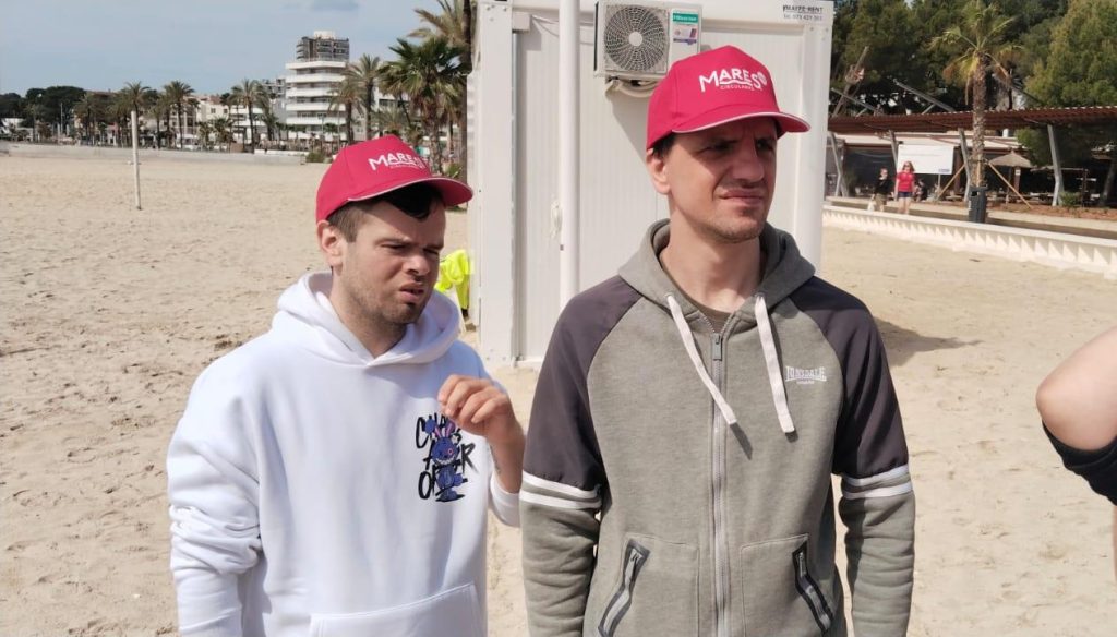 Chicos en la playa recogiendo basura