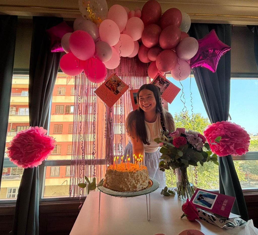 Foto de una persona delante de su tarta de cumpleaños