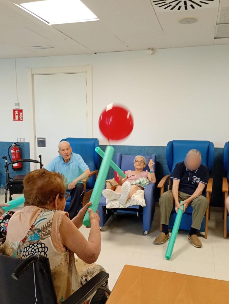 Personas mayores jugando a tenis con globos