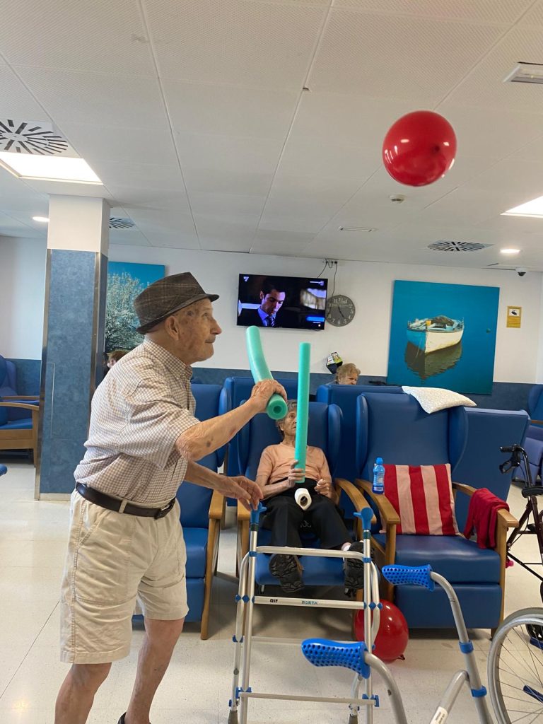 Personas mayores jugando a tenis con globos