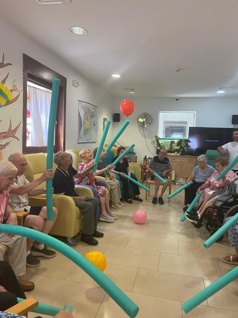 Personas mayores jugando a tenis con globos