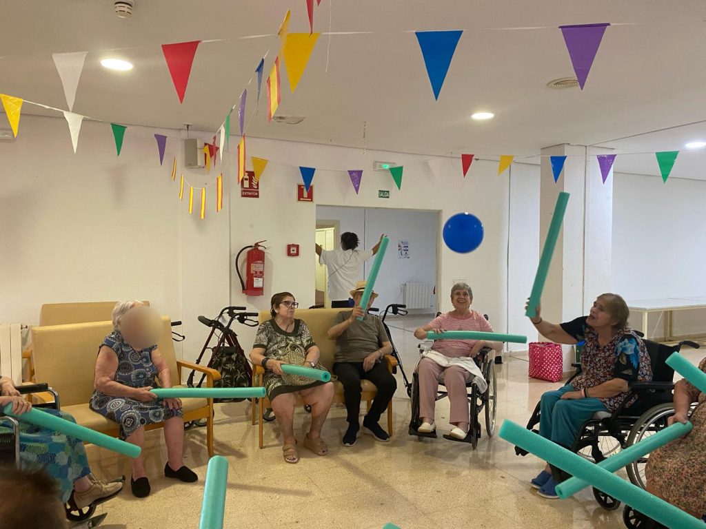 Personas mayores jugando a tenis con globos