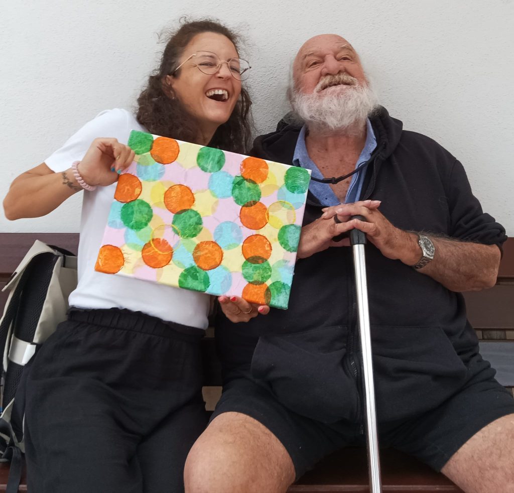 Foto de dos personas enseñando un dibujo y sonriendo